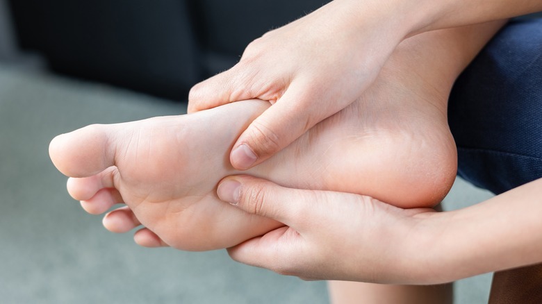 person touching foot with metatarsalgia