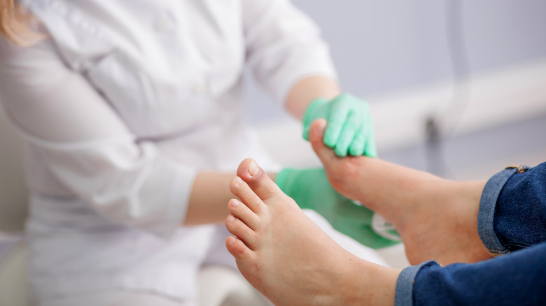 podiatrist examining foot of patient