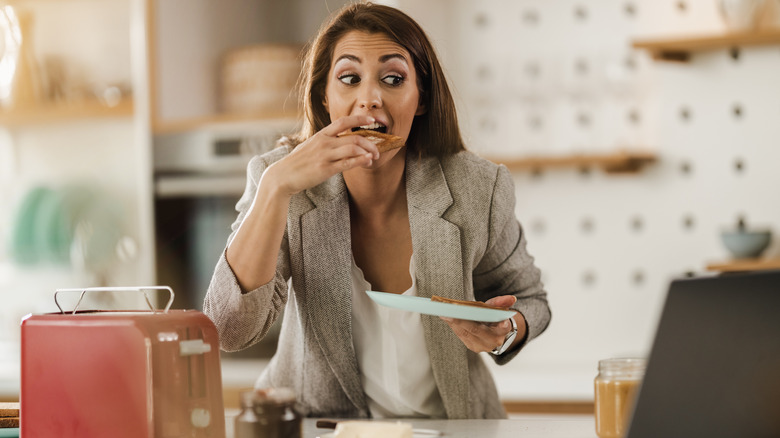 Woman eating in front of her laptop