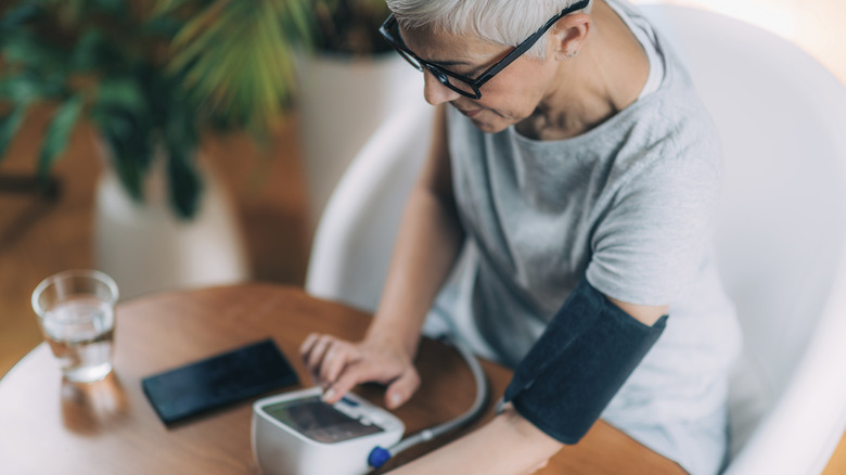 woman with short gray hair measuring blood pressure