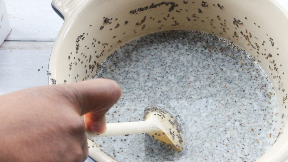 Wooden spoon stirring chia seeds in a bowl