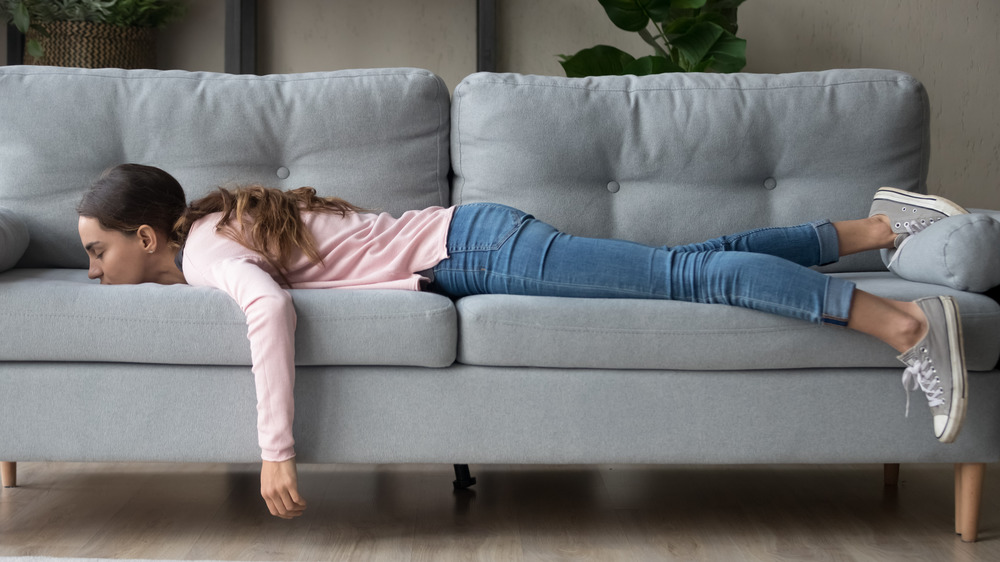 Fatigued woman lying on couch