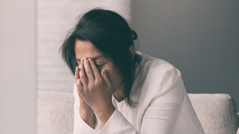 A woman with a headache holding her face in pain 