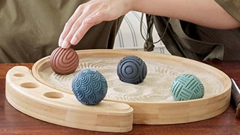 Spheres on a sand-filled dish