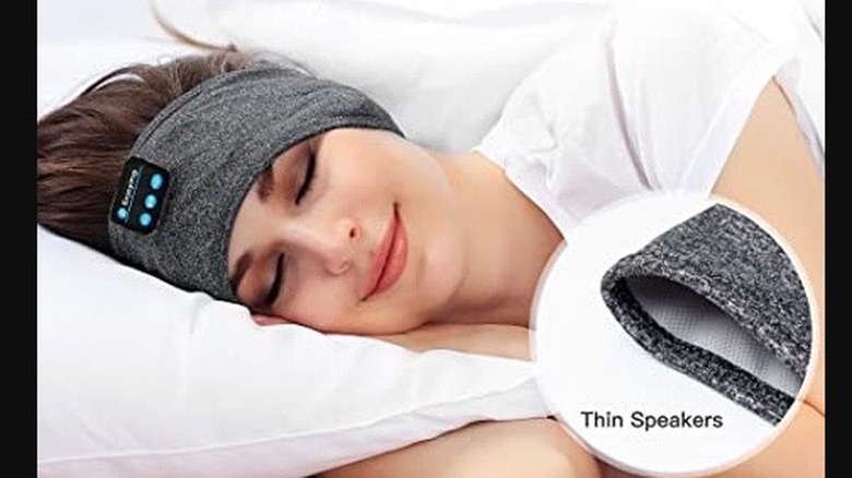 A sleeping woman wearing headband speakers