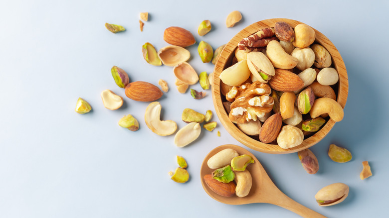 Nuts in a wooden bowl with a wooden spoon