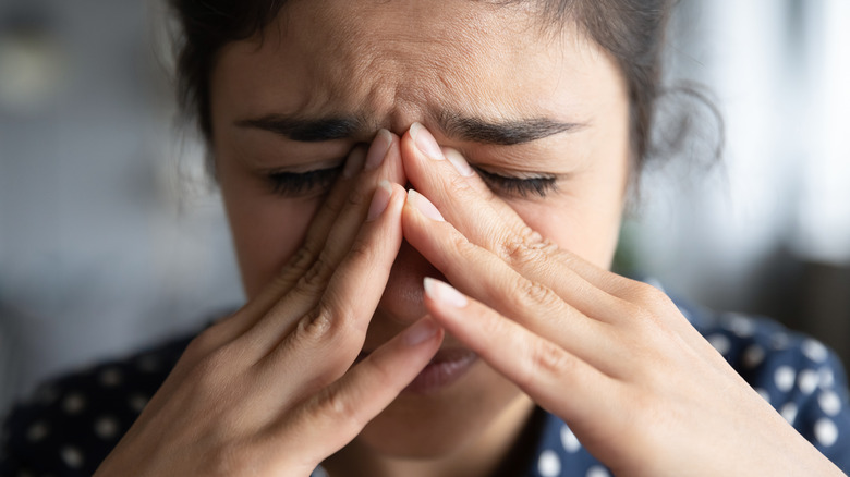 anxious woman touching nose bridge