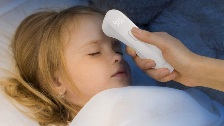 Taking child's temperature with forehead thermometer