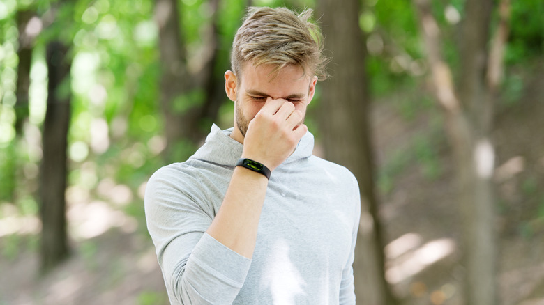 man pinching his nose