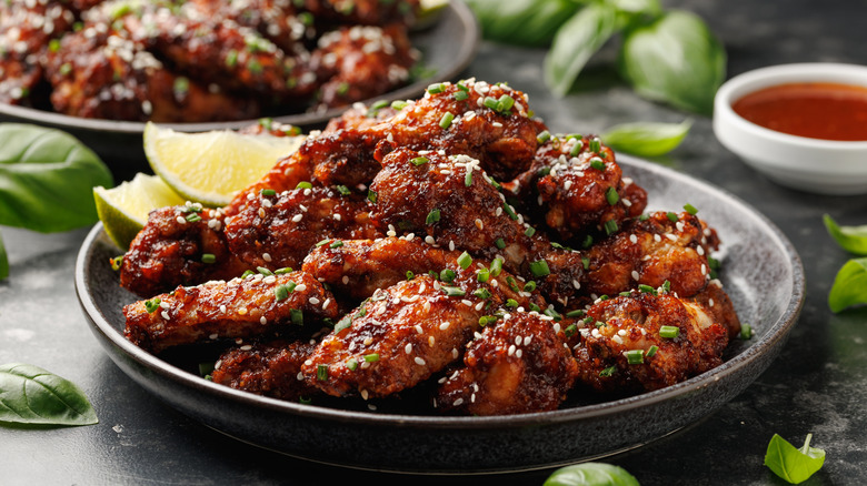 A plate of chicken wings with sesame seeds