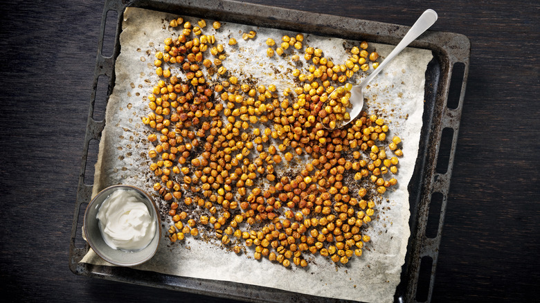 A tray of roasted chickpeas with a side of sour cream