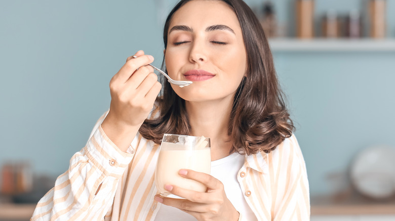 woman eating tasty yogurt