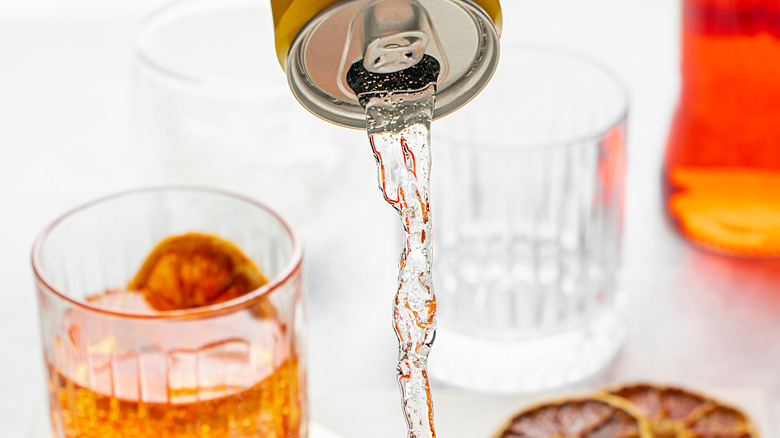 Alcoholic beverage and soda being poured