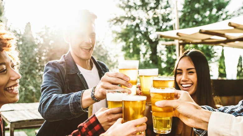 group of friends standing around a table drinking beer brunch