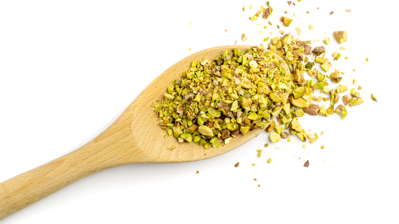 crushed pistachios on a wooden spoon