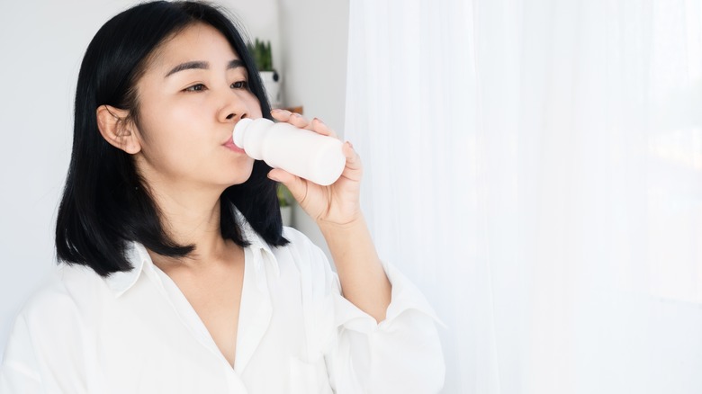 woman drinking bottled yogurt