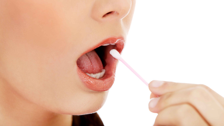 woman putting swab in mouth