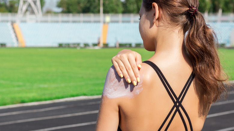 woman putting on sunscreen