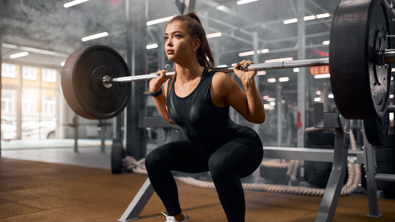 woman lifting barbell in gym