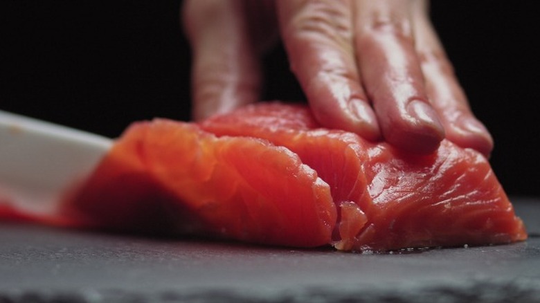 Sushi chef slicing salmon