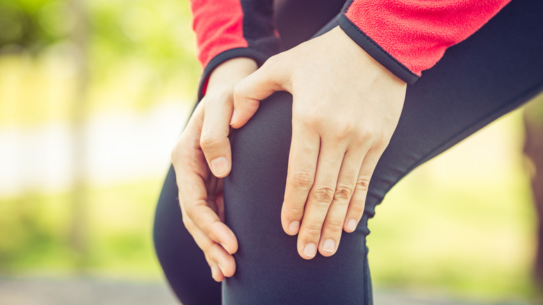 Close up of a runner holding their knee