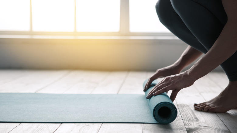 Woman unrolling a yoga mat
