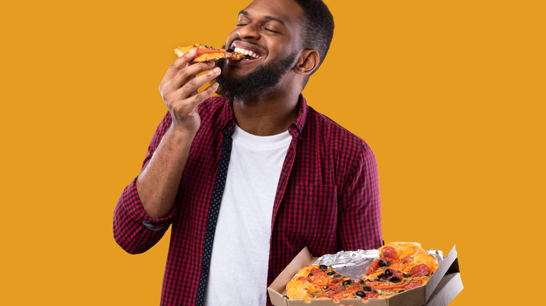 man eating pizza slice