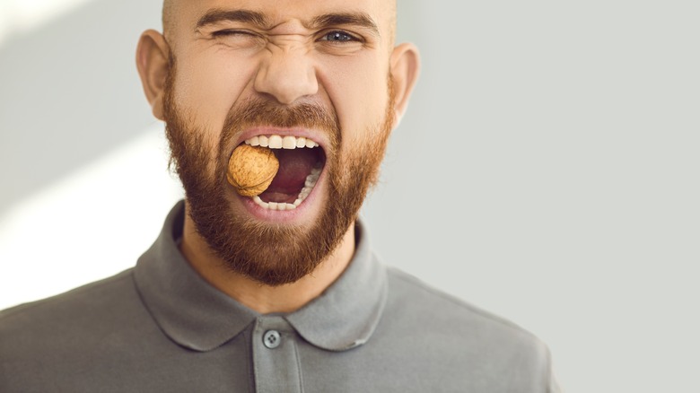 man biting on a nut