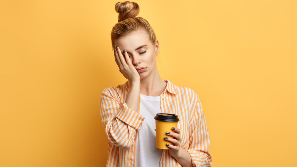 Woman tired and holding coffee