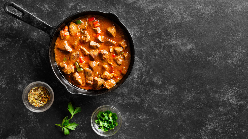 chicken liver in a pan, with bowls of herbs on side