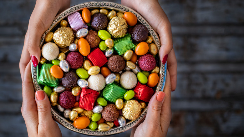 two people holding a bowl of candy