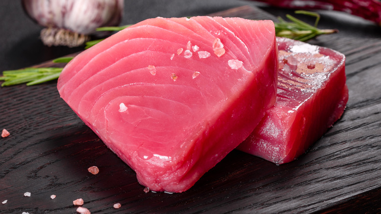 Two fresh tuna fillets on a wooden cutting board 