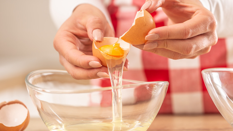 Person in an apron separating eggs