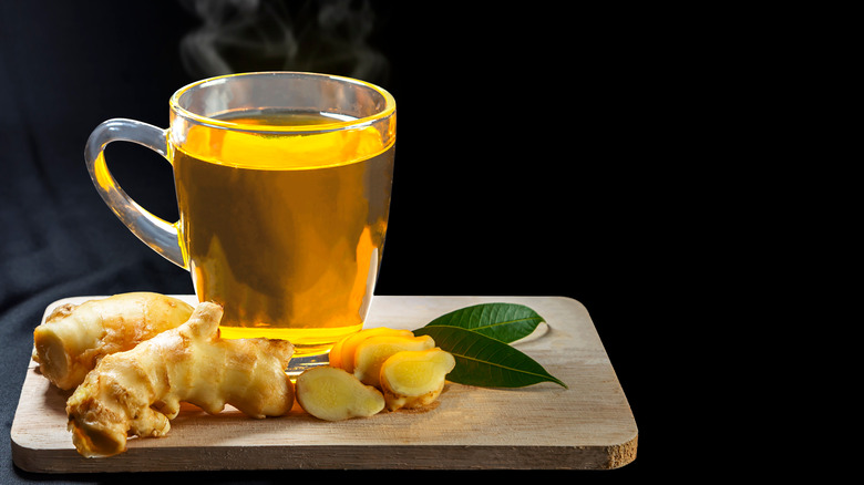 A glass of ginger tea with ginger root