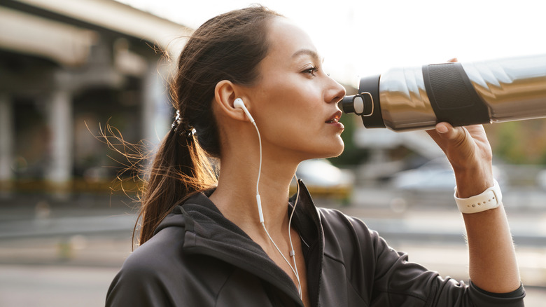 woman drinking from steel water bottle