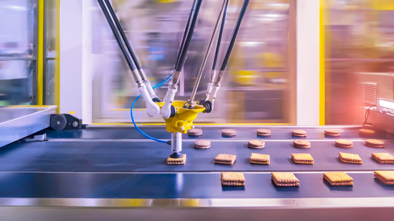 Cookies on a conveyor belt being processed by a machine