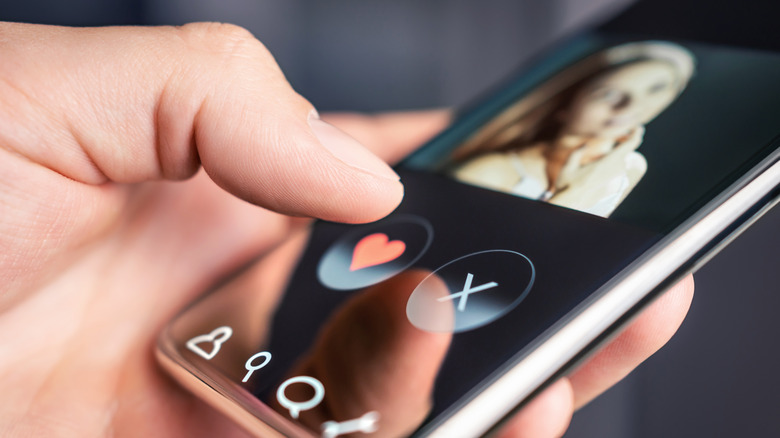 closeup of a personal holding a smartphone with a dating app