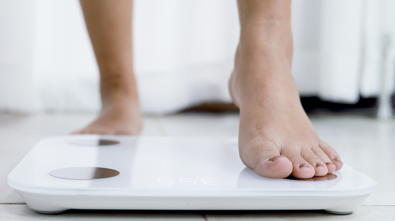 woman's feet stepping on scale