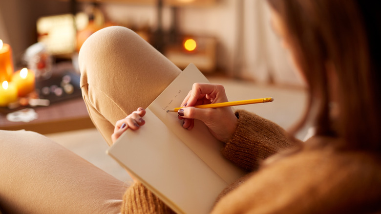 closeup of a woman journaling in her cozy home