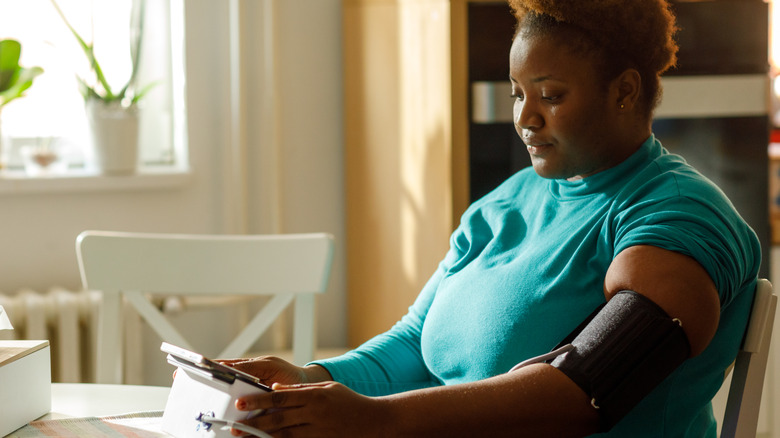 Woman checking her blood pressure at home