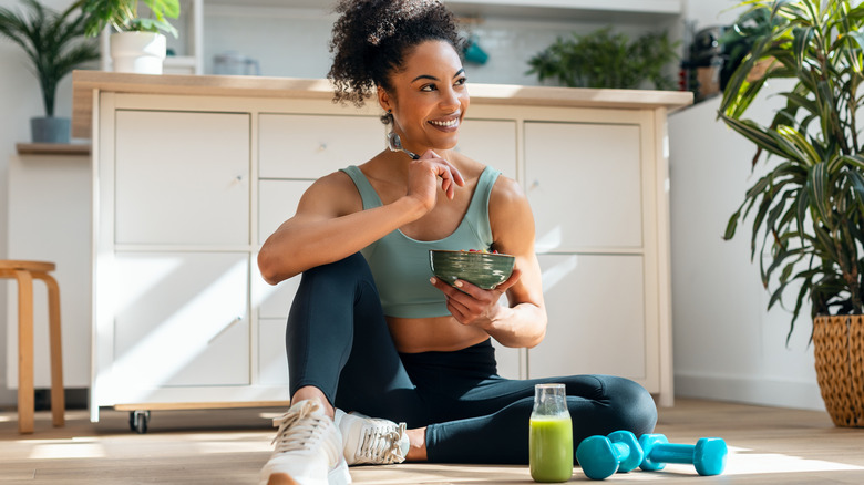 Woman sitting on the floor eating fruit