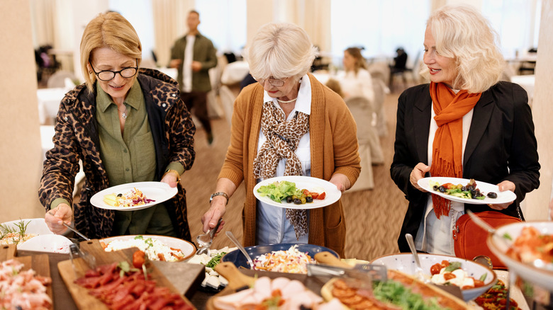 People filling their plates at a buffet