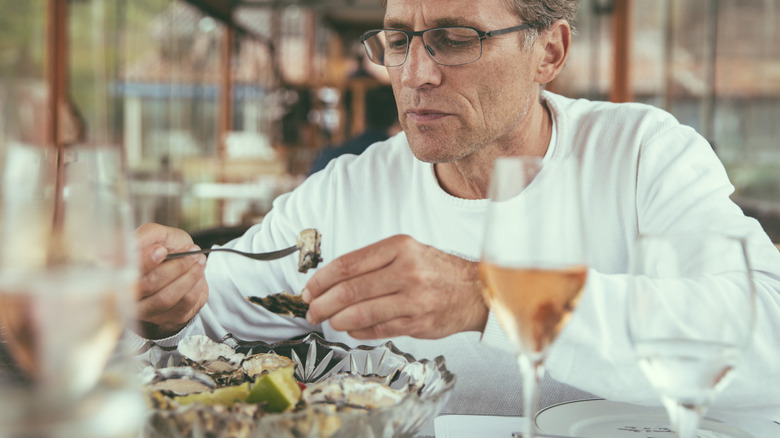 A man eating oysters at a restaurant