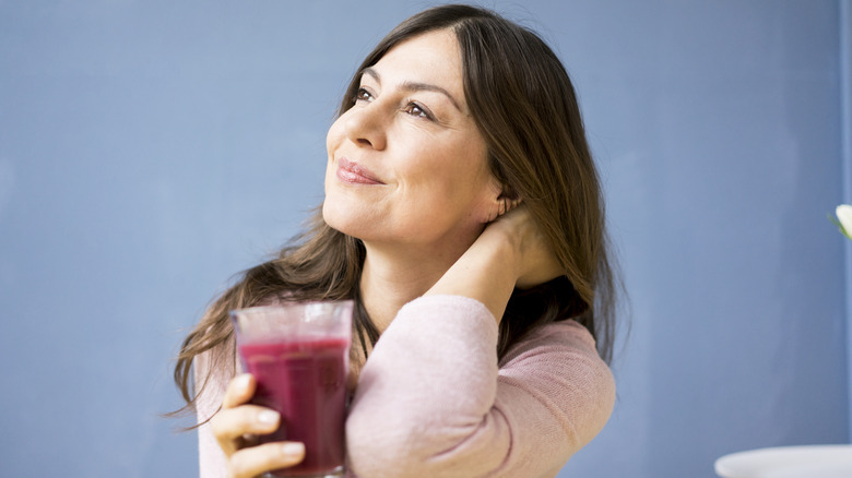 Woman drinking a glass of blueberry juice