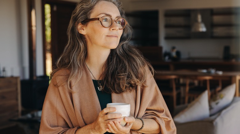 Woman sipping tea while gazing out the window