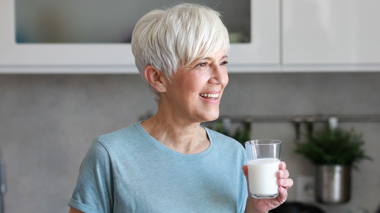 Senior woman smiling as she drinks milk