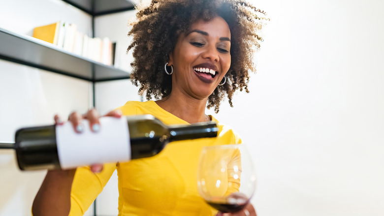 Woman pouring a glass of red wine