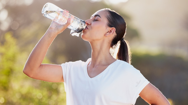 woman drinking water outdoors
