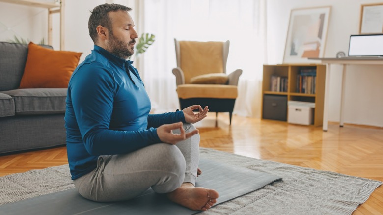 middle-aged person meditating at home