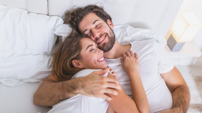 couple smiling in bed morning